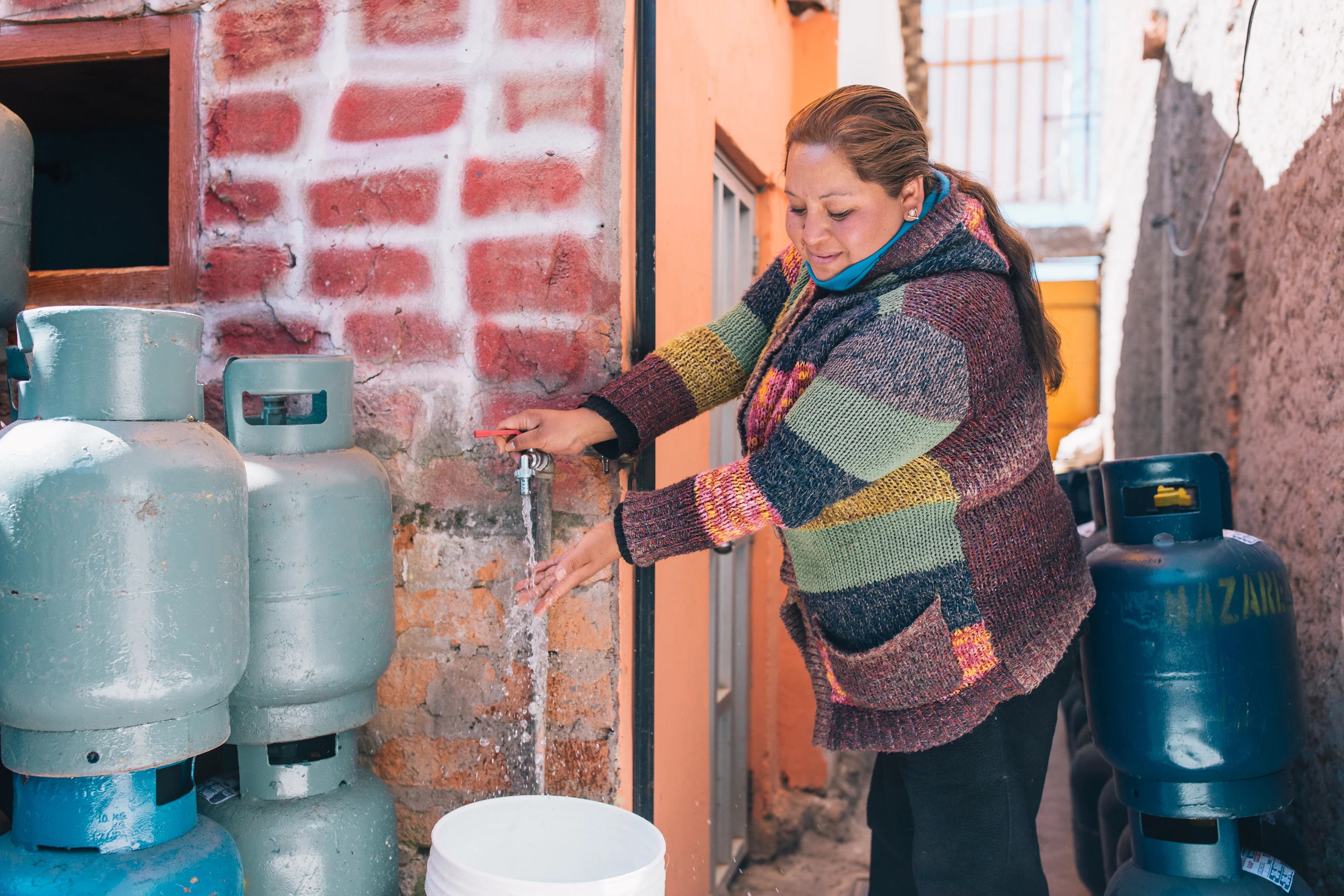 Peru - Woman pouring water from tap.jpg