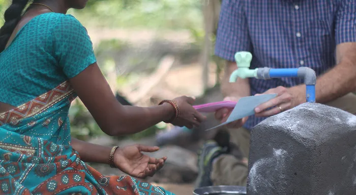 Gary White sitting with a woman in India speaking about WaterCredit.