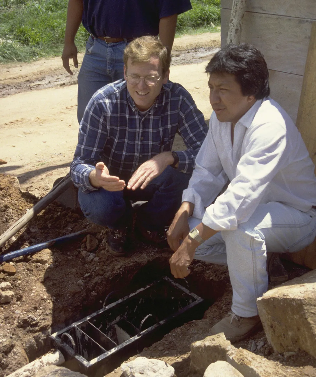 Gary White sitting with a man talking about safe water solutions.