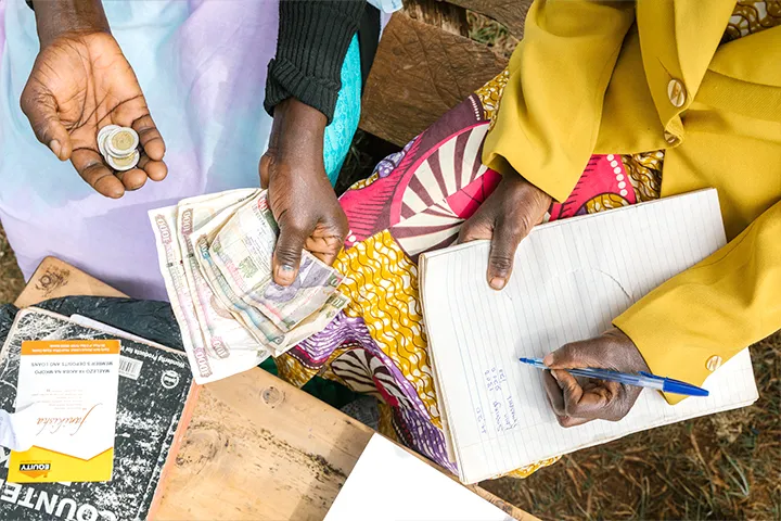 Woman making a payment on her microfinance loan for a water or sanitation solution.