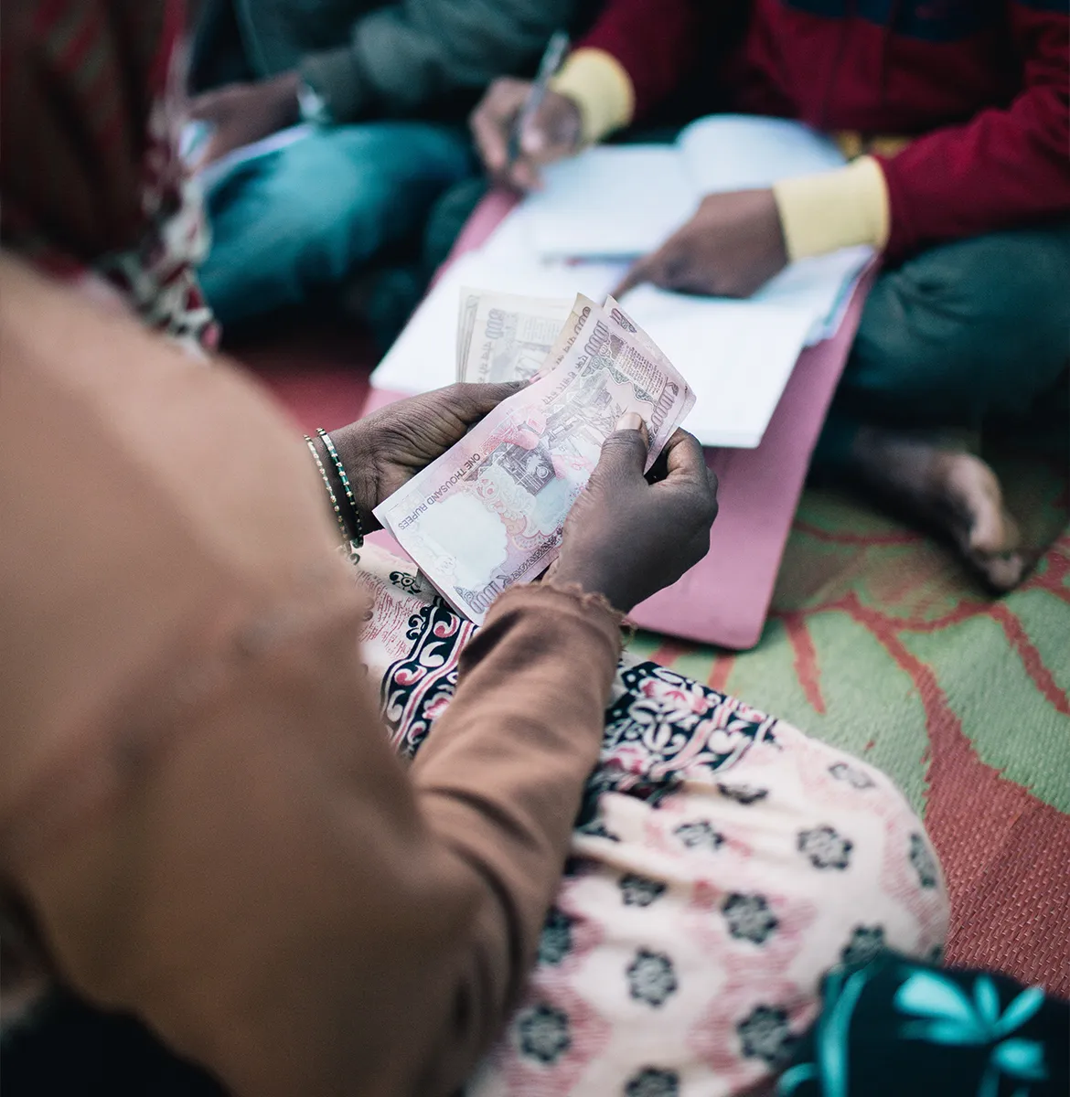 Woman making a payment on her microfinance loan for a water or sanitation solution.