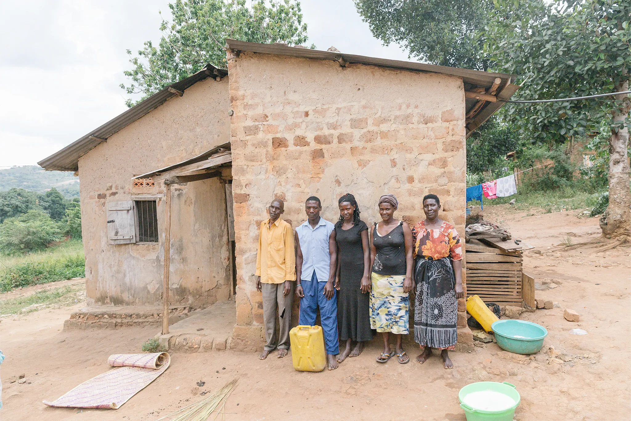 Narwoga and her family standing outside of their home in Uganda.