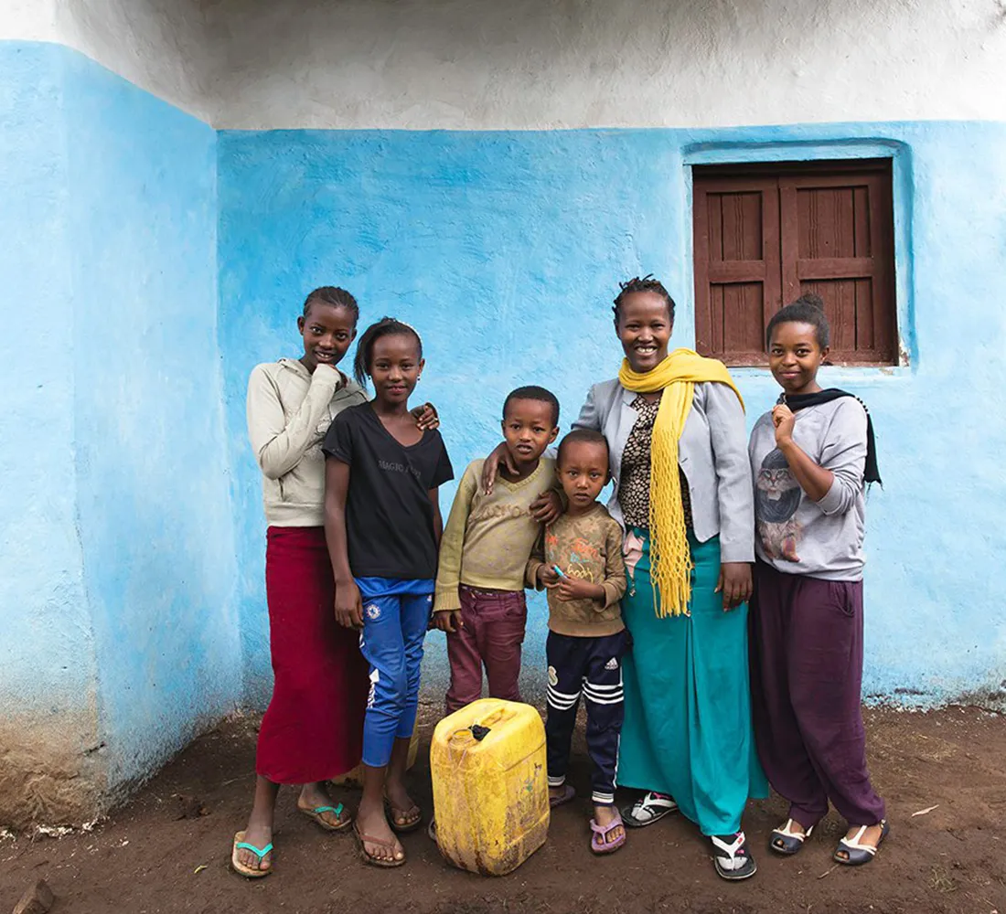 A mother and her 5 children standing together in front of their home in Ethiopia.