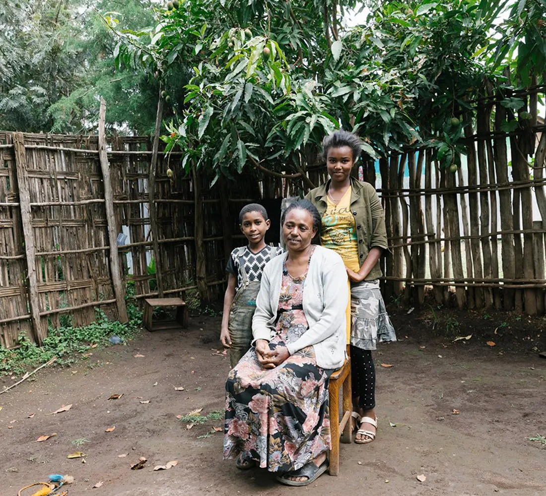 Lomitu and her two children outside of their home in Ethiopia.