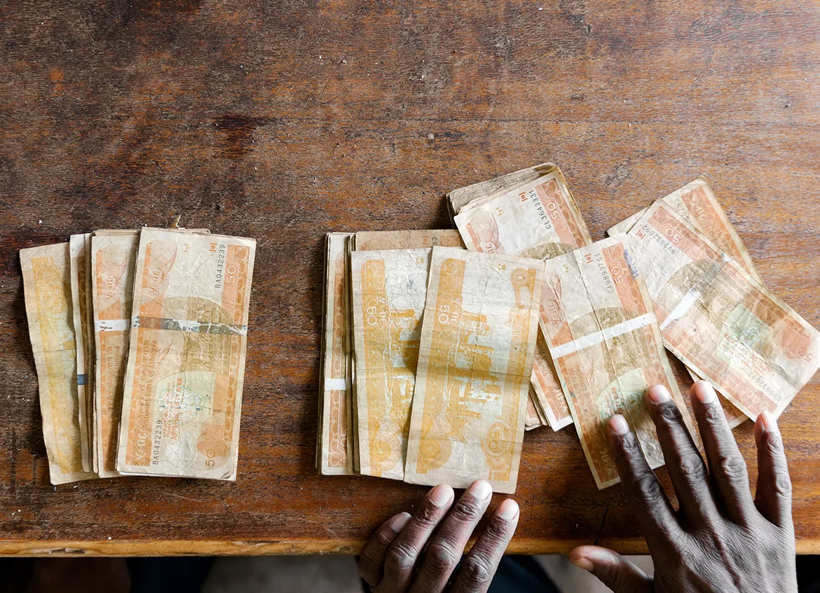 Several 50 Ethiopian Birr banknotes laid across a wooden table.